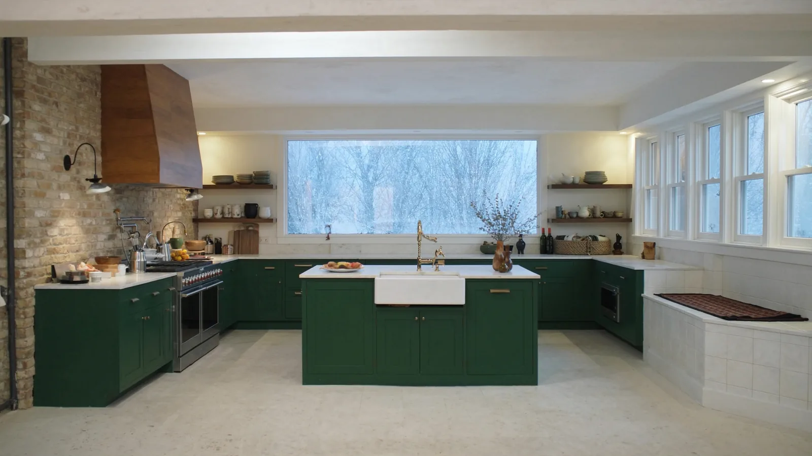 The same kitchen after remodel — deep green Craftsman cabinetry, quartz counters, walnut open shelving